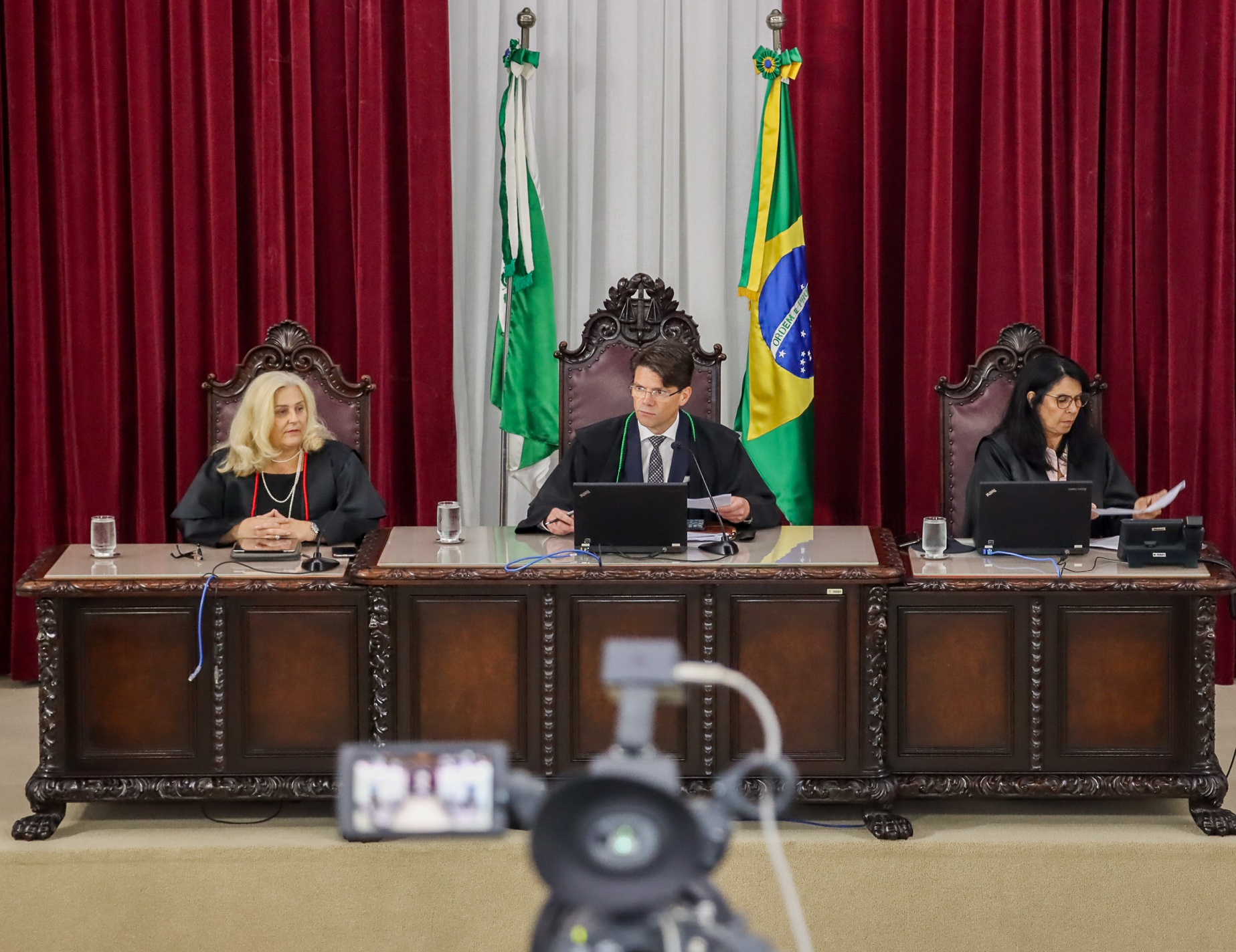 Entre a procuradora-geral do Ministério Público de Contas (MPC-PR), Valéria Borba (à esquerda na foto), e a secretária do Tribunal Pleno, Maria das Graças Greco, o vice-presidente do TCE-PR, conselheiro Ivens Linhares, preside sessão presencial do colegiado, substituindo o presidente, conselheiro Fernando Guimarães. Foto: Fabiano Contador/TCE-PR