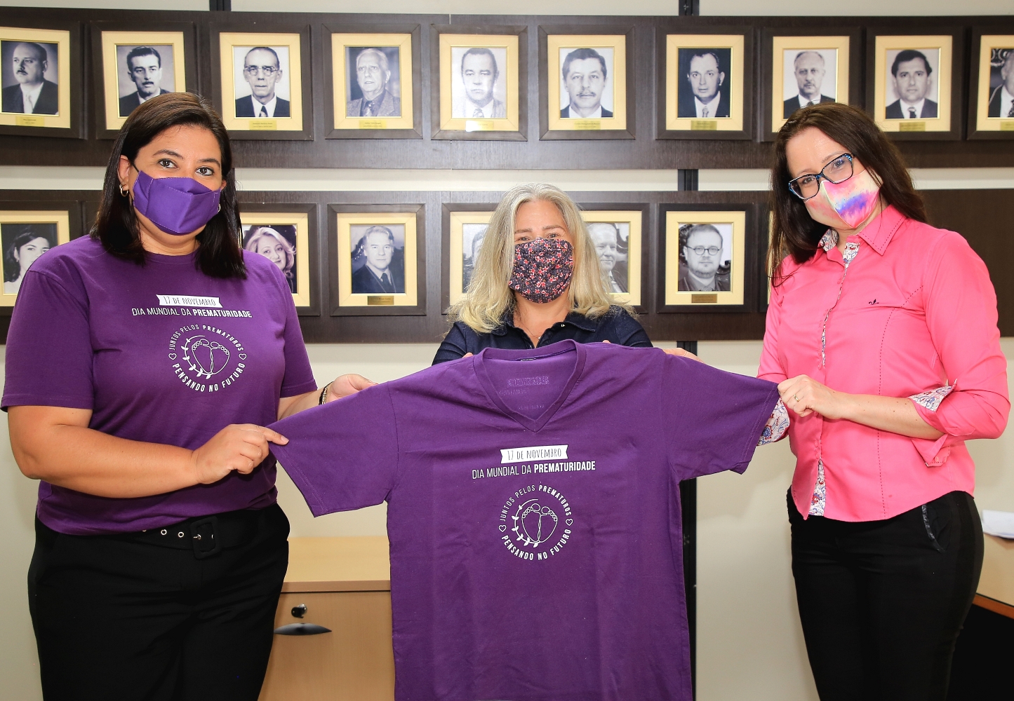 Acompanhada pela procuradora Juliana Reiner (à direita da foto), a procuradora geral do MPC-PR, Valéria Borba, recebe camiseta da campanha Novembro Roxo, entregue por Cristiane de Mello, da ONG Prematuridade. Foto: Wagner Araújo/Divulgação TCE-PR