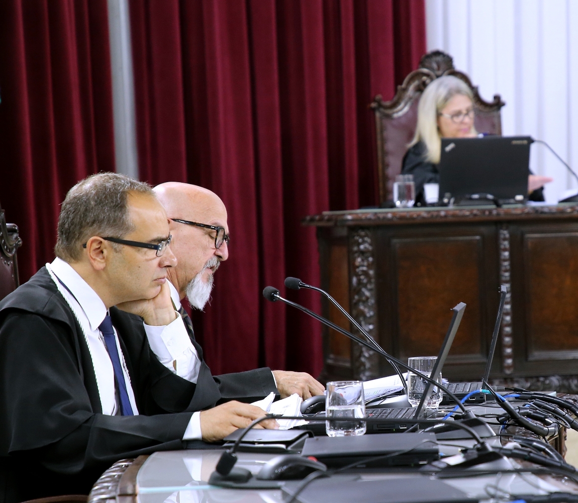 Ao lado do auditor Thiago Cordeiro, o conselheiro Fernando Guimarães relata processo em sessão da Primeira Câmara do TCE-PR; ao fundo, a procuradora do Ministério Público de Contas (MPC-PR) Valéria Borba. Foto: Wagner Araújo/Divulgação TCE-PR