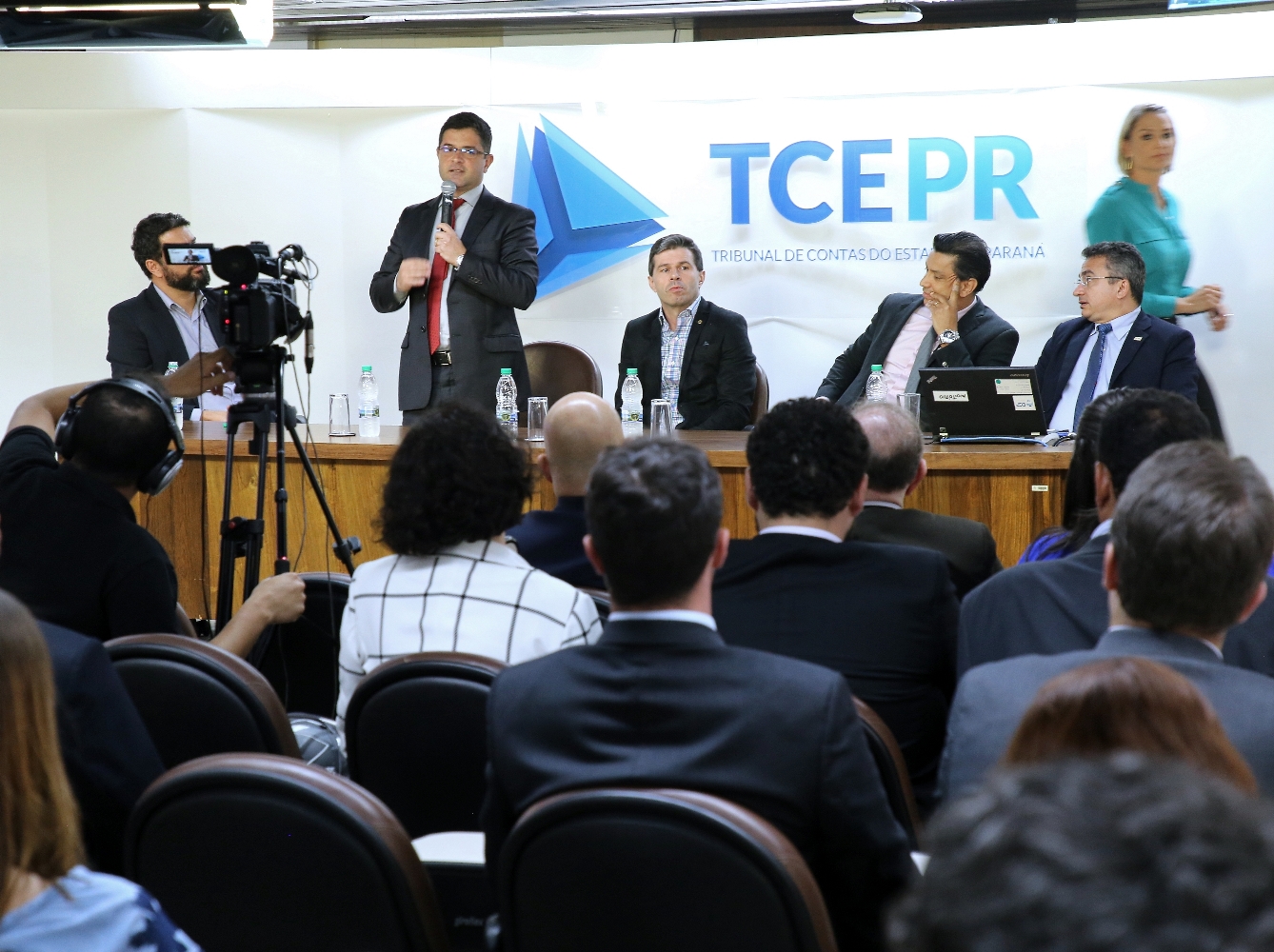 Ao lado do procurador-geral do Ministério Público de Contas, Flávio Berti, o coordenador-geral de Fiscalização, Rafael Ayres (em pé), participa da apresentação dos resultados de convênios do TCE-PR com a Universidade Positivo. Foto: Wagner Araújo/Divulgação TCE-PR