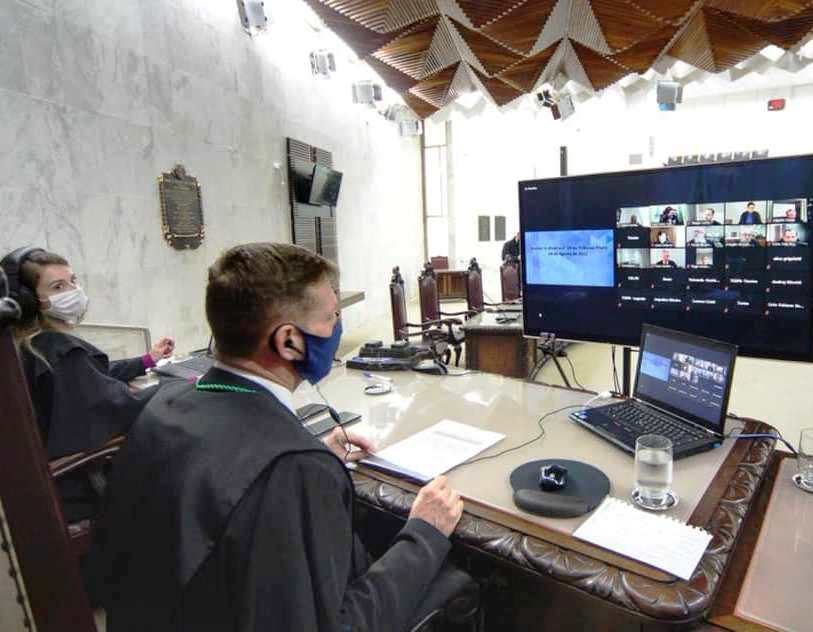 Do Plenário do TCE-PR, ao lado da secretária Aline Grigoletti Costa, o conselheiro Fabio Camargo preside sessão do Tribunal Pleno, realizada por videoconferência. Demais conselheiros, auditores e a procuradora-geral do Ministério Público de Contas, Valéria Borba, participam da sessão por meio de conexão remota. Foto: Denis Ferreira Neto/Divulgação TCE-PR
