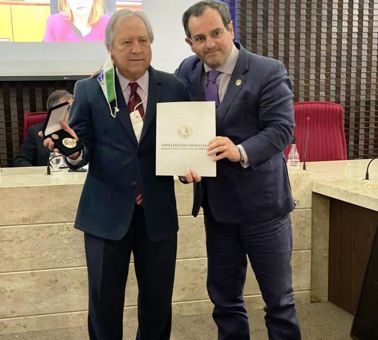 O conselheiro Ivan Bonilha, presidente do IRB, entrega a Medalha de Mérito Rui Barbosa ao conselheiro Nestor Baptista, que também representou o presidente do TCE-PR, conselheiro Fabio Camargo, na homenagem.