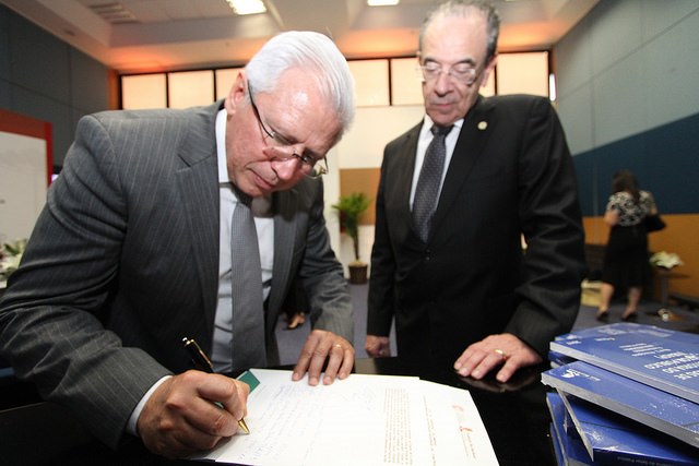 Observado pelo presidente do Instituto Rui Barbosa, conselheiro Sebastião Helvecio, o presidente do TCE-PR, conselheiro Durval Amaral, assina ata de fundação da Amerai. Foto: Wagner Araújo/Divulgação TCE-PR