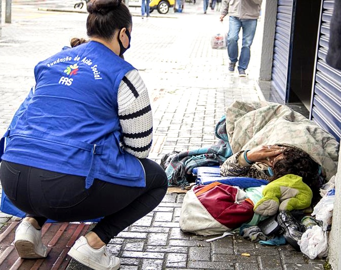 Funcionária da Fundação de Ação Social (FAS) da Prefeitura de Curitiba aborda pessoa em situação de rua na área central da capital paranaense. Foto: Prefeitura de Curitiba/Divulgação
