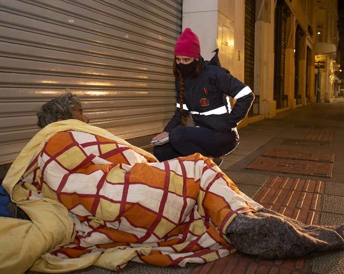 Funcionária da Fundação de Ação Social (FAS) da Prefeitura de Curitiba aborda homem em situação de rua na área central da capital paranaense. Foto: Prefeitura de Curitiba/Divulgação
