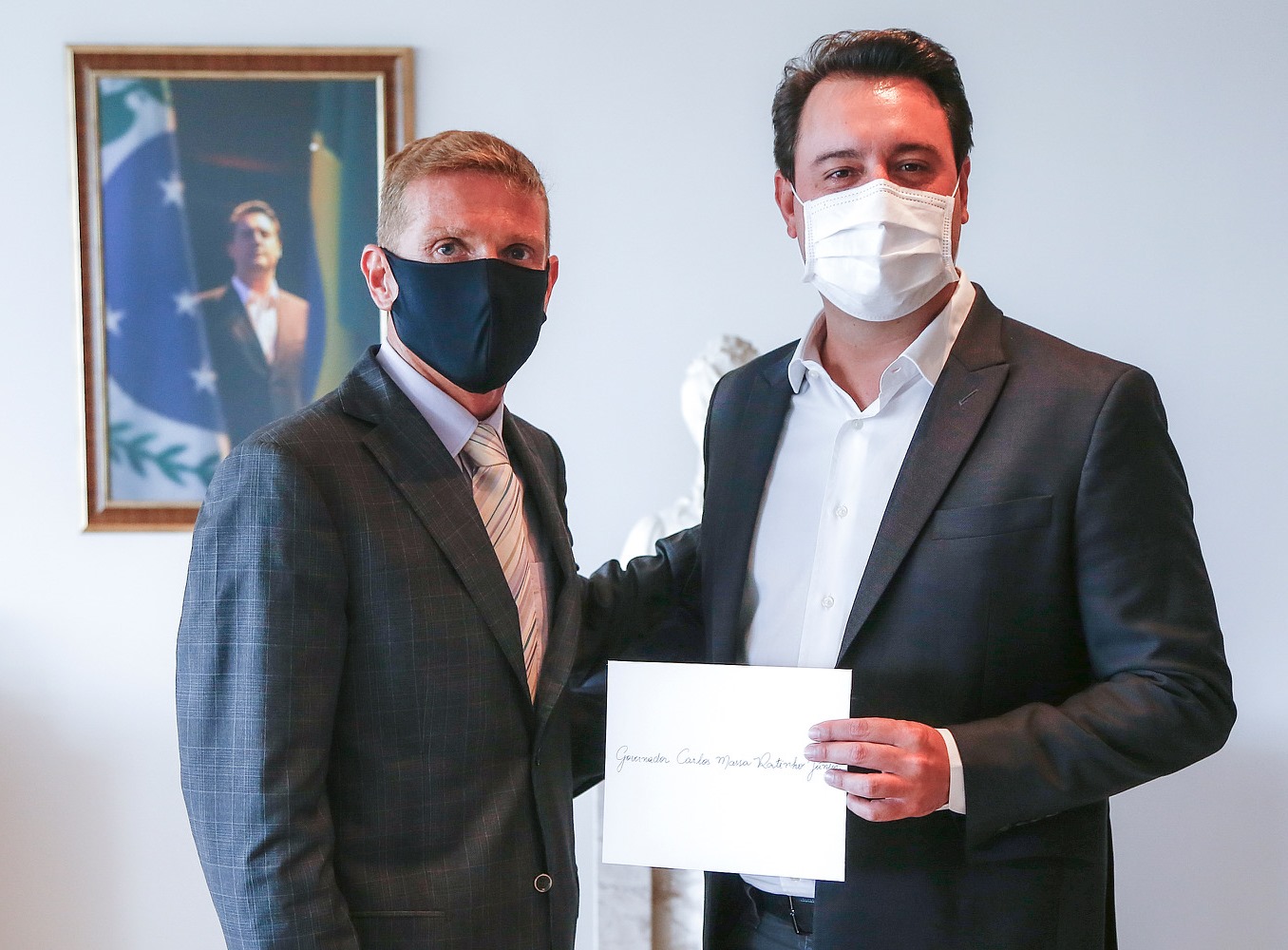 O conselheiro Fabio Camargo entrega ao governador, Carlos Massa Ratinho Junior, o convite para sua posse como presidente do TCE-PR no biênio 2021-2022. Foto: Agência Estadual de Notícias/Divulgação