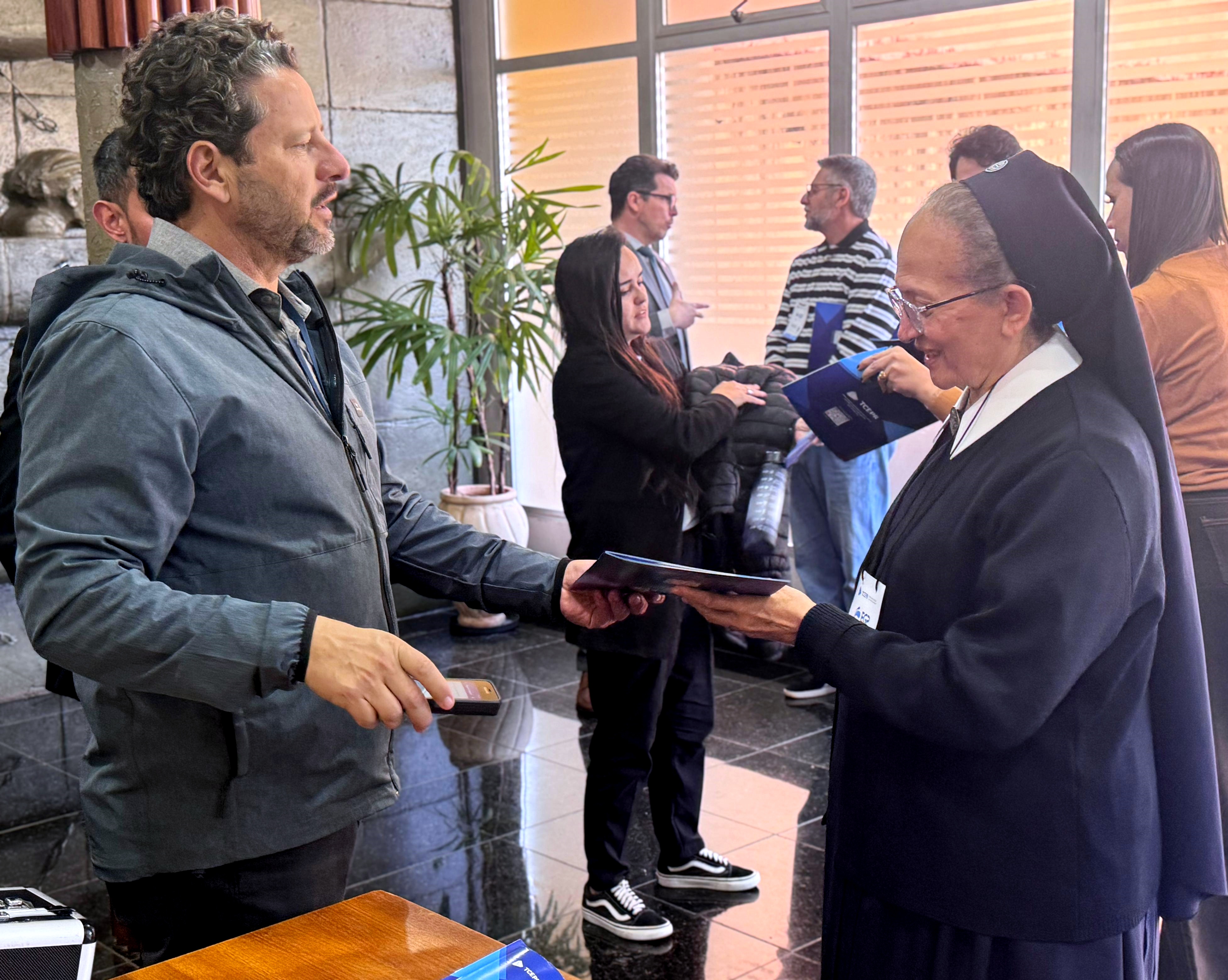 Distribuição de exemplares impressos da Cartilha Orientadora Conselhos Municipais: Participação que Fortalece a Gestão Pública, durantge o Fórum de Controle Social realizado pelo TCE-PR em Londrina, em 12 de agosto. Foto: Marcelo Lancia/TCE-PR