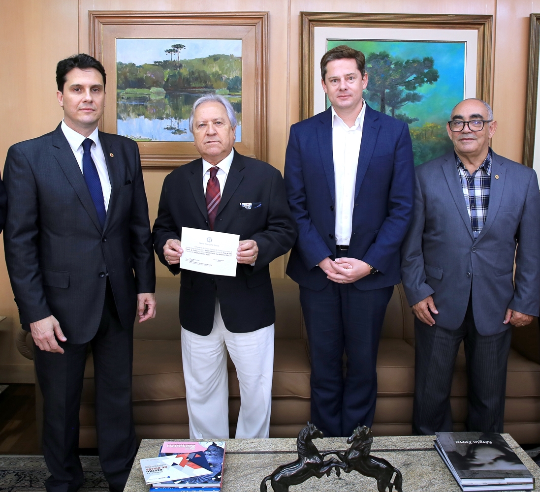 O presidente do TCE-PR, conselheiro Nestor Baptista, recebe do vereador de Curitiba Wolmir Aguiar (primeiro à esquerda) convite para homenagem ao diretor clínico do Hospital Pequeno Príncipe, Donizetti Giamberardino Filho. Foto: Wagner Araújo/Divulgação TCE-PR