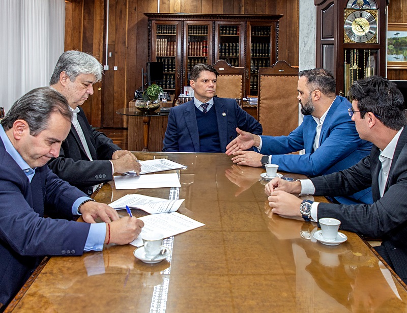 O presidente do Tribunal de Contas do Estado do Paraná, conselheiro Ivens Linhares, assina Termo de Ajustamento de Gestão (TAG) formalizado entre o TCE-PR e a Secretaria de Estado da Educação com o titular da Seed-PR, Roni Miranda, nesta quarta-feira (20 de agosto), com a presença dos conselheiros Ivan Bonilha e Maurício Requião. Foto: Mauro Beghetto Penteado/TCE-PR