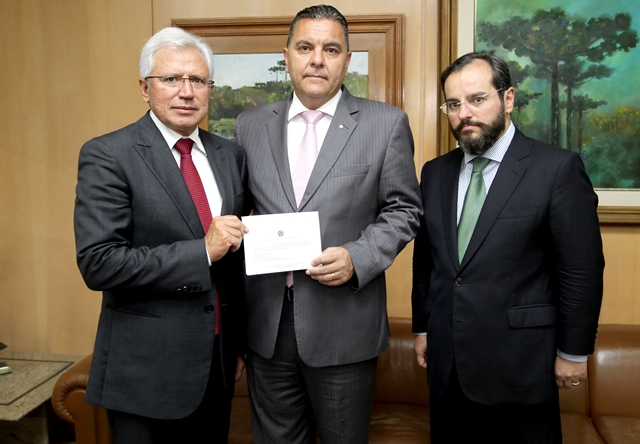 Ao lado dos conselheiros Durval Amaral e Ivan Bonilha, o presidente do Tribunal Regional Eleitoral do Paraná, desembargador Adalberto Xisto Pereira, mostra convite para a nova etapa do recadastramento biométrico de eleitores, iniciada em abril. Foto: Wagner Araújo/Divulgação TCE-PR