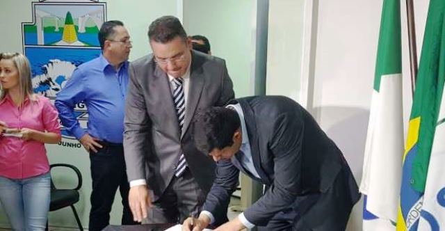 O vereador Rogério Quadros, presidente interino da Câmara Municipal de Foz do Iguaçu, assina notificação entregue pelo assessor jurídico da Presidência do TCE-PR, Cláudio Henrique de Castro. Foto: Reprodução CATVE