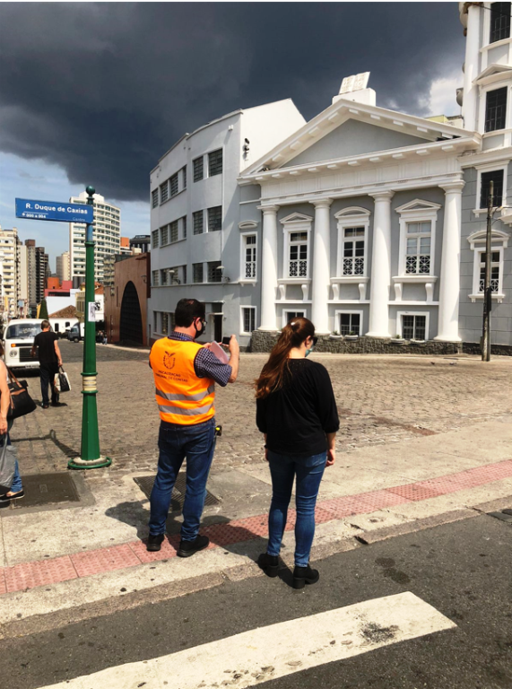 Servidores do TCE-PR verificam conformidade de calçada de concreto com faixa elevada e piso tátil, que auxilia a locomoção de pessoas com deficiência visual, em fiscalização sobre a mobilidade urbana em Curitiba. Foto: Divulgação/TCE-PR